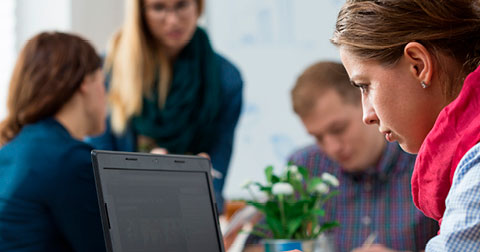 woman working on laptop outside of the group